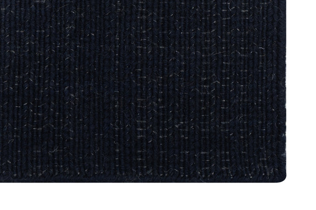 Close-up of Solid Black Texture Hand-Woven Soumak woolen rug for bed rooms, offices, and dining spaces. 